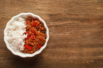 Chili Con Carne with rice in bowl on wooden background