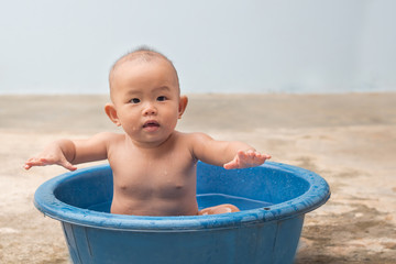 Cute New Born Baby playing ball in the plastic basin during shower,children learning