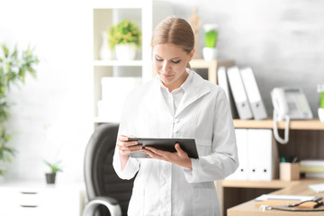 Young female receptionist holding tablet computer in hospital