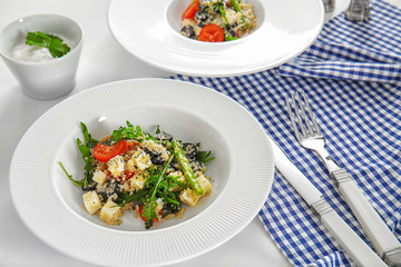 Plate with quinoa salad on table