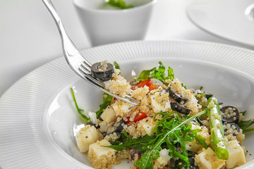 Fork and plate with delicious quinoa salad, closeup