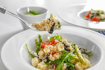 Fork and plate with delicious quinoa salad, closeup