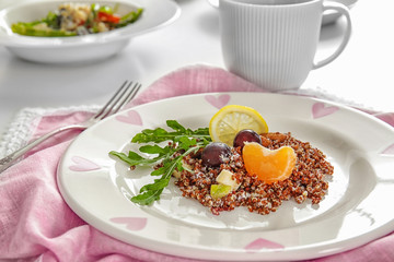Plate with quinoa and fruits on table, closeup
