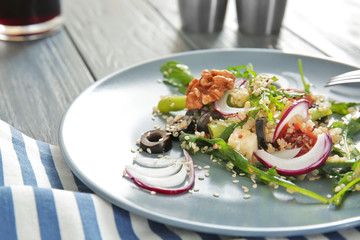Plate with quinoa salad on wooden table, closeup