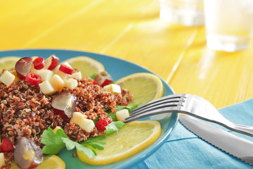 Plate with quinoa salad on table, closeup