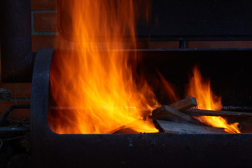 Fototapeta premium Burning firewood in the barbecue at backyard close up.