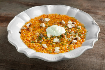 Plate with tasty lentil soup on table