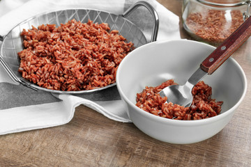 Bowl and dish with cooked rice on table