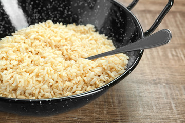 Dish with cooked rice on table