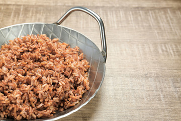 Dish with cooked rice on table
