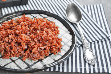 Plate with cooked rice on table