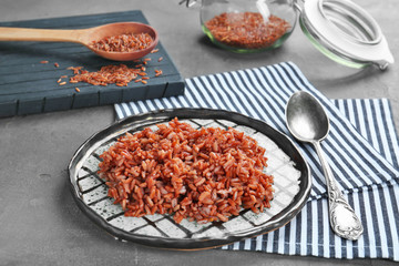 Plate with cooked rice on table