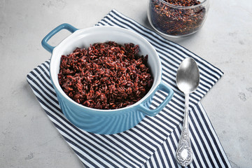Dish with cooked rice on table