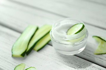Jar with cucumber cream on table