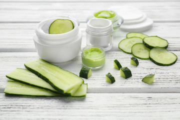 Beautiful composition with slices of cucumber and ingredients for mask on table