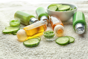 Composition of cucumber beauty products on towel