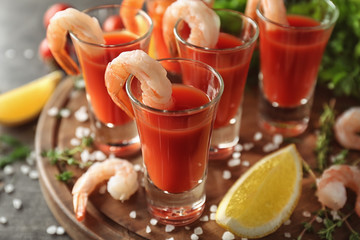 Shrimps and tomato sauce in glasses on wooden board