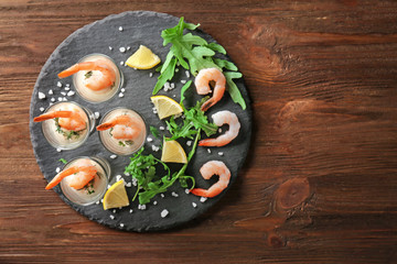 Composition with glasses of white sauce and shrimps on table
