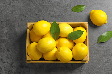 Wooden crate with fresh lemons on table