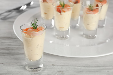 Glass of white sauce with shrimp on table