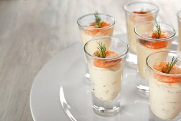 Plate with glasses of white sauce and shrimps on table, closeup