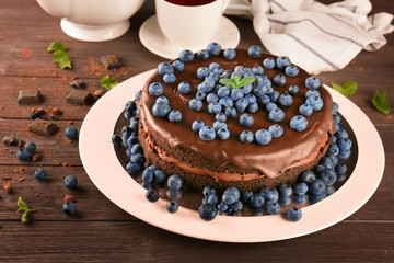 Plate with chocolate cake on table