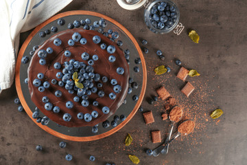 Board with chocolate cake on table