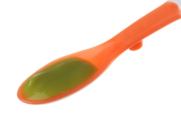 Plastic spoon with baby food on white background