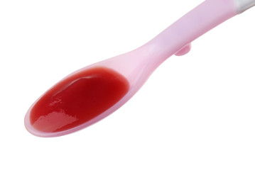 Plastic spoon with baby food on white background
