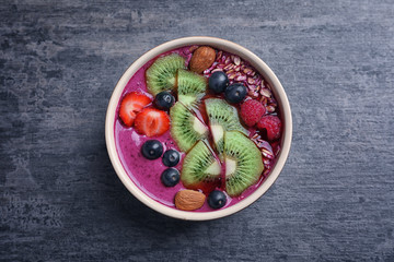 Healthy breakfast with delicious acai smoothie in bowl on table