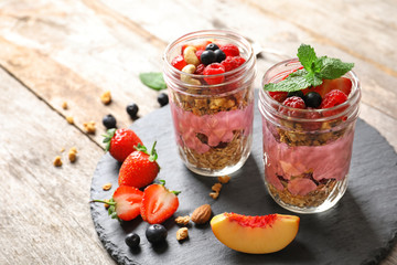 Healthy breakfast with delicious acai smoothie in jars on slate plate