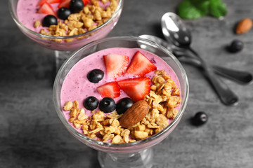 Healthy breakfast with delicious acai smoothie in glass dessert bowl on table