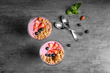 Healthy breakfast with delicious acai smoothie in glass dessert bowls on table