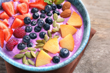 Healthy breakfast with delicious acai smoothie in bowl, close up