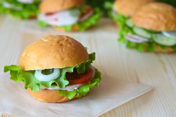 sandwich with tomato lettuce and ham and onion on a wooden table