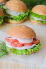 sandwich with tomato lettuce and ham and onion on a wooden table