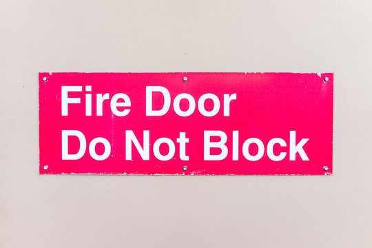 Closeup Of Red Sign With Fire Door Do Not Block Words Warning