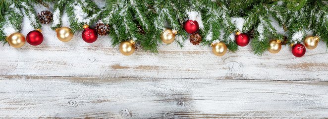 Fototapeta na wymiar Christmas branches with golden and red ornaments with snow on rustic white wooden background