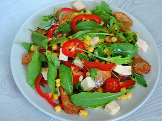 Salad on a plate. Fitness salad with corn. Nutritious fitness salad.Arugula corn pepper cheese. Top view.