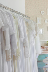 Interior of bridal salon. Beautiful wedding dress on a hangers. In vintage style