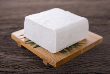 square tofu on plate and on wooden background