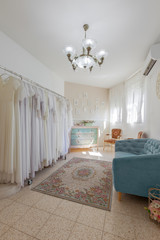 Interior of bridal salon. Beautiful wedding dress on a hangers. In vintage style