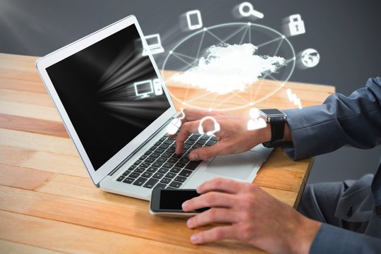 Composite image of cropped image of businessman using laptop