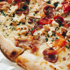 Italian pizza with cheese,ham,salami,mushrooms and tomato, Traditional beked cuisine bread,pie,sliced, tasty dinner