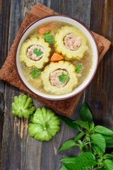 Thai food,bitter gourd soup with pork in a bowl on wooden background.Top view of food