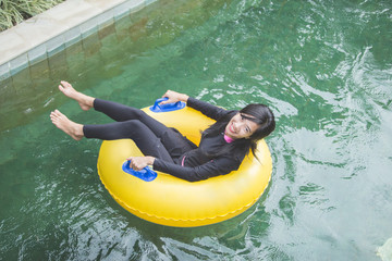 young woman enjoying tubing at lazy river pool