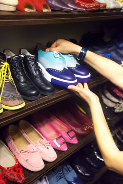 Woman choosing shoes on your closet for footwear.