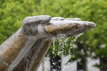 Hands statue from which water flows. Monument decoration on the
