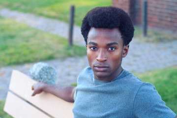 handsome young african man portrait sitting in a park