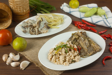 Steamed spice fish in banana leaf and spiced roe on a wooden plate